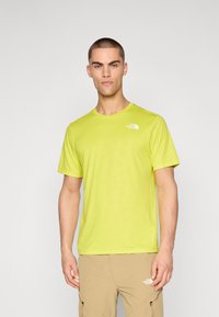 Camiseta de manga corta en un brillante color verde lima, con un patrón texturizado y un pequeño logo blanco en el lado izquierdo del pecho. Fabricada en un material suave y ligero.