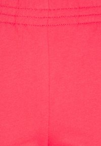 Růžová bavlněná látka s hladkým povrchem, s elastickým pasem a jednoduchým, nezdobeným designem.