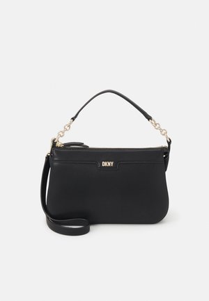 Black DKNY handbag with gold chain-accented handle, zippered top, and detachable shoulder strap on plain light background.