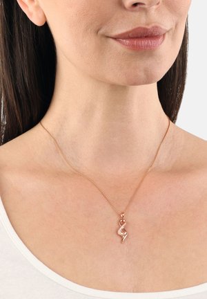 Collana in oro rosa con un pendente intrecciato e una pietra preziosa trasparente. Catenina delicata con maglie sottili, indossata all'altezza della clavicola.