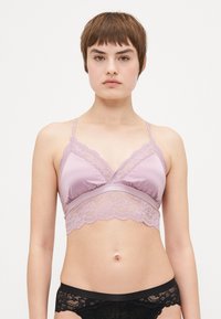 Lavender bralette med blondekant, justerbare stropper og et blødt satinmateriale. Den nederste kant har et blomstermotiv i blonde.
