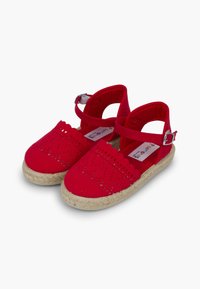 Espadrillas in canvas rosso con design traforato, cinturini alla caviglia e suola in juta intrecciata. Punta arrotondata e materiale leggero.