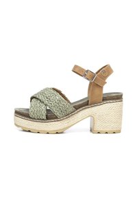 Sandalia de plataforma marrón con tiras de tela verde trenzada, hebilla ajustable en el tobillo, suela beige texturizada y diseño de tacón cuadrado.
