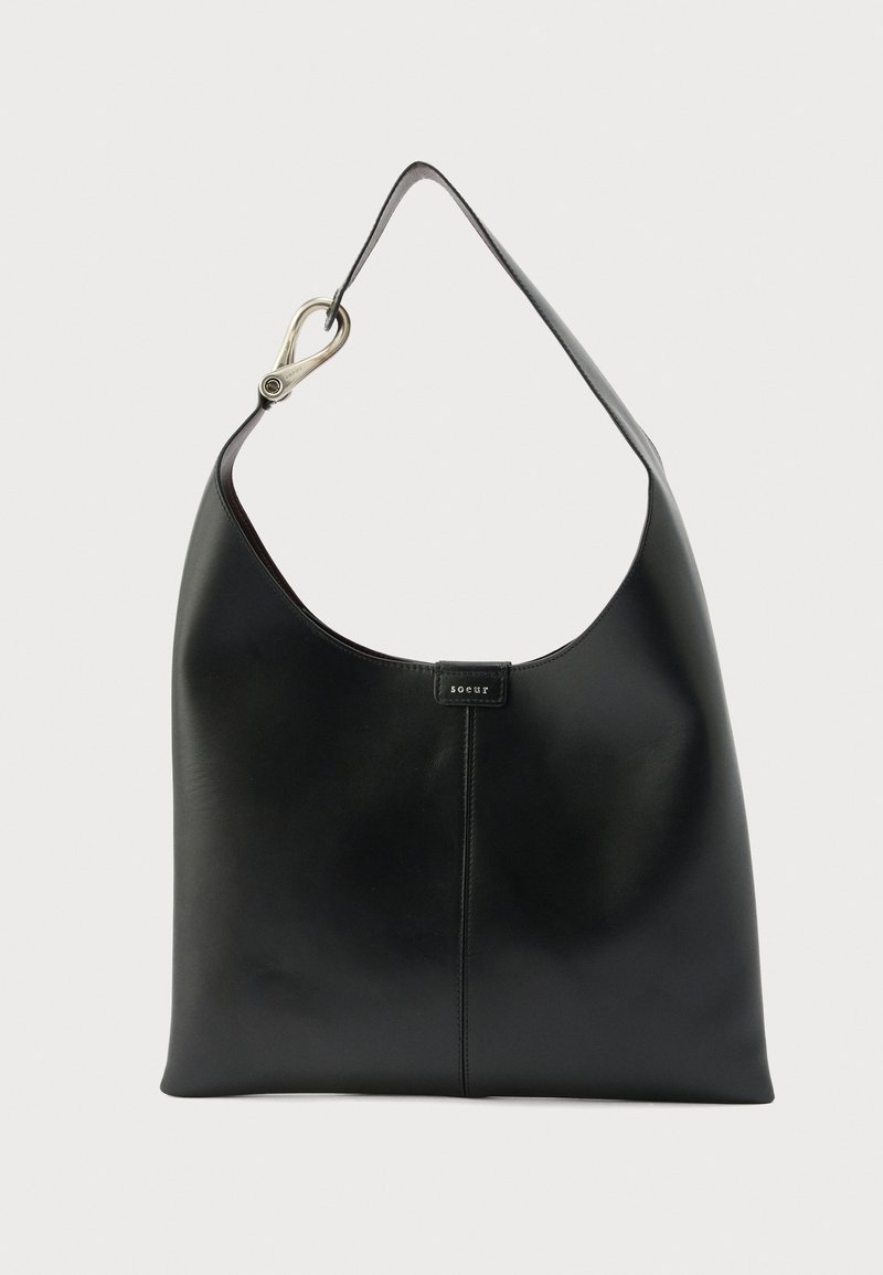 Μαύρη δερμάτινη τσάντα ώμου με έναν ιμάντα που διαθέτει ασημένιο κούμπωμα και μικρή κεντρική ετικέτα μάρκας «Soeur».