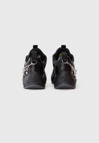 Zwarte sportieve schoenen met een gladde textuur, voorzien van zilveren kettingaccenten, een gevoerde kraag en het "Buffalo" logo geperst op de hak.