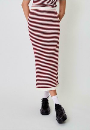 Striped midi skirt in burgundy and white ribbed knit, featuring a fitted silhouette and contrasting white hem. Paired with black shoes and white socks.