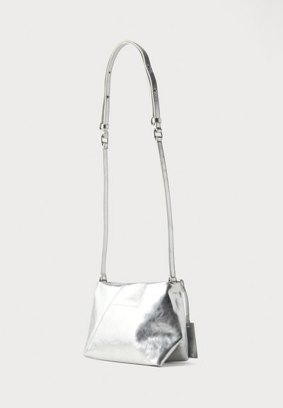 Ασημί μεταλλική δερμάτινη τσάντα crossbody με μακρύ ρυθμιζόμενο λουρί και γεωμετρικό ραμμένο σχέδιο στο μπροστινό μέρος.