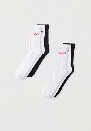 Bawełniane skarpetki w kolorze czarnym i białym, z prążkowaną fakturą i logo "HUGO" w czerwieni na każdej skarpetce. Każda para zawiera po dwie skarpetki w każdym kolorze.