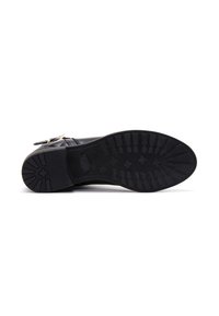 Botín de cuero negro hasta el tobillo con una textura suave, puntera redondeada y suela de goma con un diseño de tracción horizontal y en forma de estrella. Hebilla lateral ajustable.