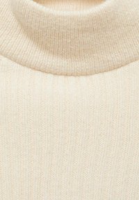 Pull à col roulé beige côtelé, avec une texture douce, un col haut et un motif tricoté vertical qui s'étend sur tout le tissu.