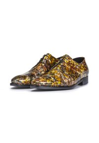 Chaussures à lacets avec une finition brillante, présentant un motif multicolore en jaune, brun et vert. Semelle noire et surface texturée.