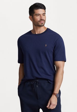 Tricou cu mânecă scurtă de culoare bleu marin, realizat din bumbac moale, având un guler rotund și un mic logo brodat pe partea stângă a pieptului.