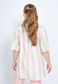 Chemise à rayures à manches courtes dans des couleurs pastel, dotée d'une coupe décontractée et d'un dos plus long, fabriquée en tissu doux et léger.