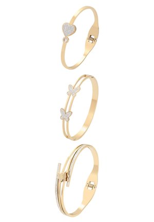 Drie gouden armbanden met hart-, vlinder- en geometrisch vlinderdessin, elk versierd met kleine heldere kristallen.