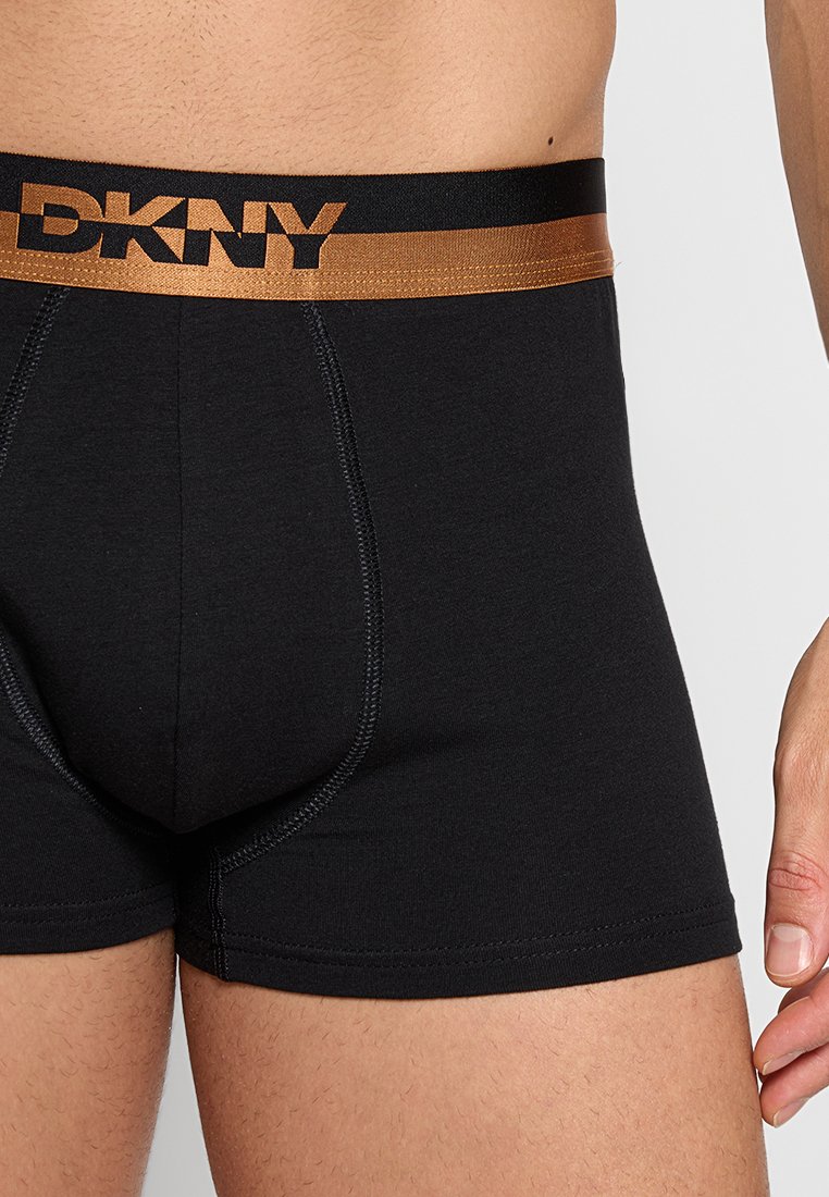 Schwarz Baumwoll-Boxershorts mit einem goldenen DKNY-Logo auf dem elastischen Bund. Sie verfügen über eine glatte Oberfläche und ein enganliegendes Design.
