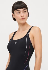 Black swimsuit with thin straps, featuring white, pink, and purple accent lines. Made of smooth, stretchy fabric with a logo.