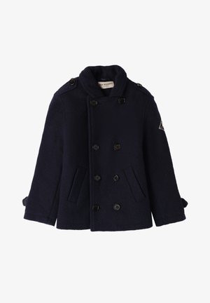 Donkerblauwe wollen peacoat met dubbele knopen, hoge kraag, zijzakken, zwarte knopen en een embleem op de linkermouw.