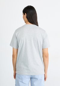 Gray cotton t-shirt with a crew neck, short sleeves, and a straight cut. Slightly textured surface with a small stain near the lower back.