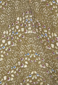 Olivgrüner Stoff mit einem verstreuten Muster aus weißen, goldenen, rosa und blauen Punkten, das ein strukturiertes, mehrfarbiges Design schafft.
