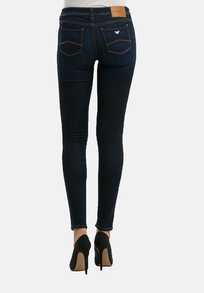 Peenikesed teksad tumesinises denimis, millel on sile pind. Omab keskmise kõrgusega vööd, tagakotte ja väikest logo vööl.