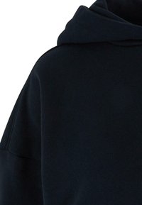 Felpa con cappuccio di un blu navy scuro, realizzata in un tessuto morbido e texturizzato, caratterizzata da un cappuccio ampio e da una vestibilità comoda. Il design senza cuciture delle spalle contribuisce al suo stile minimalista.