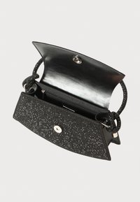 Svart håndveske med teksturert overflate som har metalltråd, magnetisk lukking og en slank, flettet stropp. Innvendig har den en glidelåslomme.