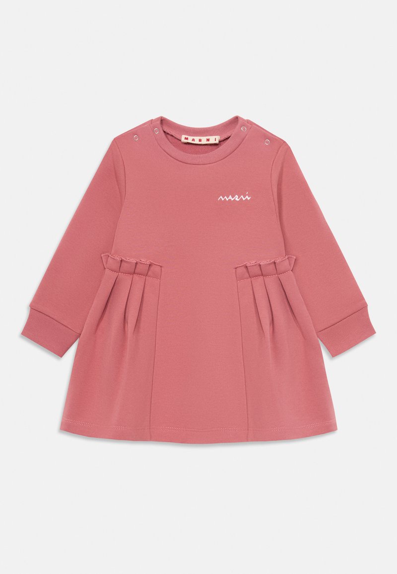 Ružové bavlnené šaty s dlhými rukávmi, vybavené okrúhlym výstrihom, malými cvočkami na pleciach a plisovanými akcentmi na sukni.