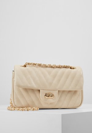 Beige quiltet håndtaske med klaplukning, guldfarvet hardware og kædestrop. Har chevron-mønster og glat lædderstruktur.
