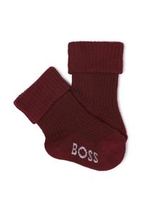 Chaussettes en coton bordeaux avec texture côtelée, haut rabattu et logo "BOSS" blanc près des orteils. Matériau doux et forme ajustée pour un confort optimal.