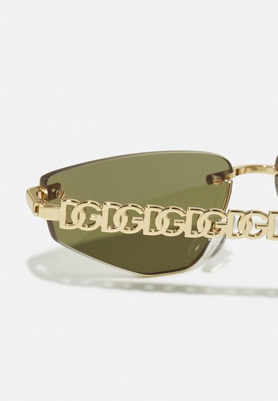 Gafas de sol con montura dorada y lentes en forma angular de color verde oliva. El diseño de cadena en las varillas presenta letras entrelazadas, añadiendo textura y detalle.