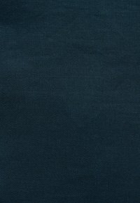 Tissu bleu foncé avec une texture tricotée serrée et uniforme.