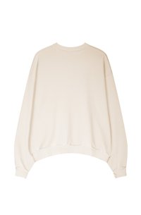 Sweatshirt over-size color crema con spalle cadenti, polsini a costine e una texture liscia. Nessun marchio o motivo visibile.