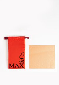 Pungă din țesătură roșie cu text negru "MAX&Co.", având un vârf cu șnur. Lângă ea, un pătrat neted din țesătură bej cu logo embosat.