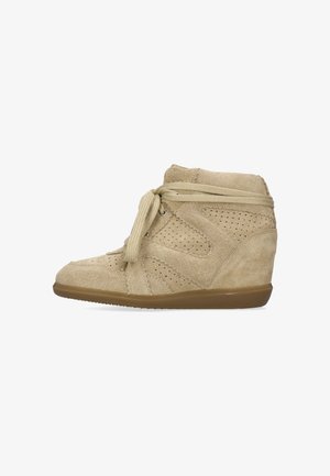Sneaker beige in suede con zeppa, dettagli traforati, lacci avvolti attorno alla caviglia e suola in gomma, vista laterale.