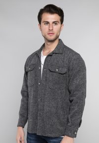 Grijs herringbone overhemdjack met lange mouwen, twee voorzakken en metalen knopen. Gemaakt van gestructureerde stof met een slim fit.