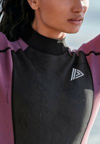Czarny i purpurowy piankowy kombinezon o gładkiej, wodoodpornej fakturze. Posiada wysoki kołnierz, dopasowany krój oraz logo na klatce piersiowej.