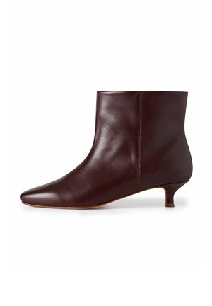 Stivale alla caviglia in pelle bordeaux con punta affusolata e tacco basso a campana. Texture liscia con dettagli di cucitura minimi e una silhouette elegante.