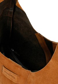 Brązowy zamszowy but o gładkiej fakturze, z suwakiem i miękką podszewką, prezentujący zaokrąglony fason.