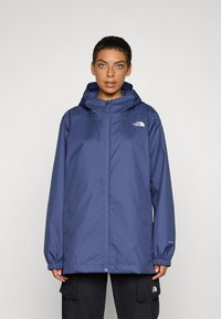 Navy blue waterproof jacket with a zip front, adjustable hood, elastic cuffs, and logo on the left chest. Smooth texture, lightweight design.