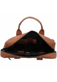 Bruine leren tas met een ritssluiting aan de bovenkant, twee handvatten en een ruime zwarte binnenkant met zakken en banden voor organisatie.