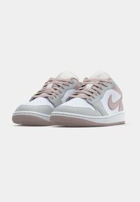 Les sneakers Nike présentent une base en cuir blanc avec des accents en suède gris clair et rose, un embout rond, un laçage à l'avant et une semelle en caoutchouc texturé.