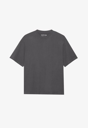 Sivá bavlnená trikó s okrúhlym výstrihom, krátkymi rukávmi a voľným strihom. Obsahuje minimálne švy a žiadne viditeľné vzory alebo grafiku.