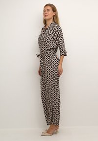 Jumpsuit a fantasia nera e rosa con colletto, maniche a tre quarti e cintura da annodare in vita, realizzato in un tessuto leggero e liscio.