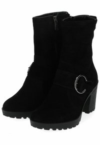 Botas de ante negras hasta el tobillo con cierre de cremallera, punta redonda y una correa decorativa que presenta un acento en forma de anillo plateado. Tacón de goma apilado.