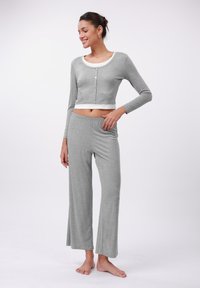 Ensemble de pyjama en coton gris comprenant un haut cropped à manches longues avec un col rond et un bouton de fermeture, associé à un pantalon long ample.