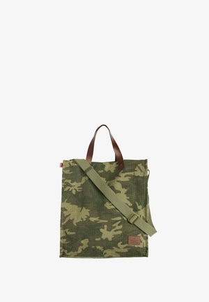 Grøn camouflage shopper-taske med justerbar skulderrem og brune læderhåndtag, firkantet form og stoftekstur.