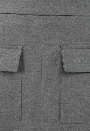 Harmaa kangas, jossa on teksturoitu pinta ja kaksi etutaskua läpällä. Minimalistinen muotoilu, siistit linjat, eikä näkyvää metalliosaa.