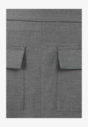 Harmaa kangas, jossa on teksturoitu pinta ja kaksi etutaskua läpällä. Minimalistinen muotoilu, siistit linjat, eikä näkyvää metalliosaa.