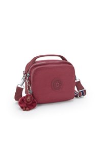 Borsa a tracolla in tessuto rosso con manico, due scomparti con zip, un logo circolare e un charm fluffy attaccato alla zip.