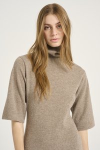 Maglione a collo alto beige realizzato in un morbido tessuto testurizzato; presenta maniche corte e larghe e una silhouette aderente.